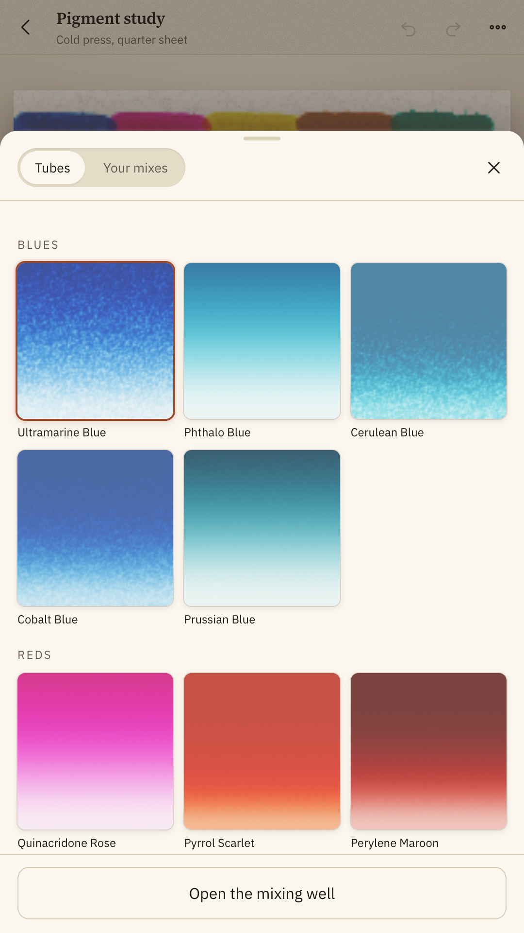 The pigment drawer open over a painting, showing graded wash cards for the blues and the reds.